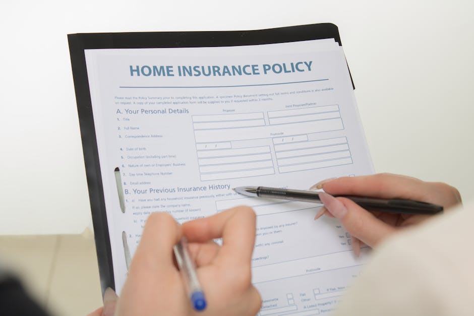 A person filling out a home insurance policy form titled 'HOME INSURANCE POLICY' on a black clipboard with a silver clip, held in their left hand, while writing with a silver pen in their right hand. The form includes sections for personal details and previous insurance history. The background is plain and light-colored, emphasizing the document and the person's hands, with bright lighting highlighting the surface and the paper's white color. This image relates to domestic cleaning and maintenance services, as promoted by Islington Carpet Cleaning, emphasizing the importance of proper documentation and protection for residential properties.